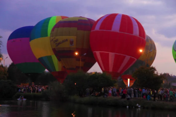 Globos de aire caliente volando en el cielo de la noche cerca del lago —  Fotos de Stock