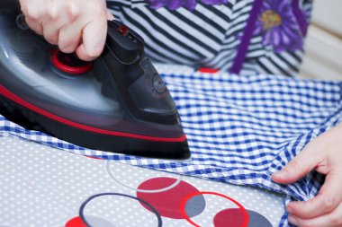Ev hanımı ütü tahtası closeup üzerinde rahat bir giysi ütüleme