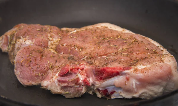 Fresh raw pork steak with spices roasting on frying pan — Stock Photo, Image