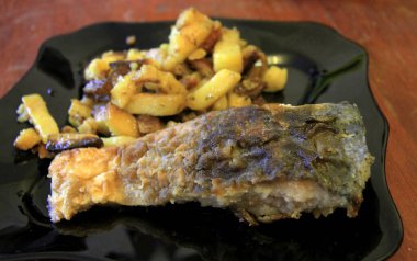 Kızarmış patates ve kızarmış balık ve siyah plaka