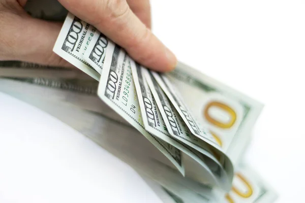 Hombre pagando por pila de dólares de papel EE.UU. En el fondo blanco —  Fotos de Stock