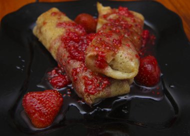 Süzme peynir ve çilek reçeli o tarafından doldurulmuş krep kadar haddelenmiş