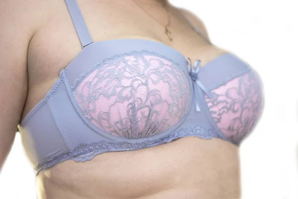 Adult woman trying on a new pink and grey bra isolated — Stock Photo, Image
