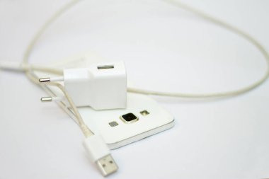 Beyaz telefon ve telefon kablosu beyaz düzlükte izole edilmiş.