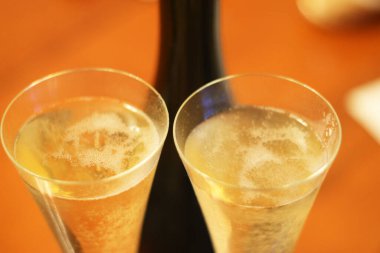 Ahşap arka planda içmeden önce bir şişe şampanya ve iki bardak soğuk şampanya.