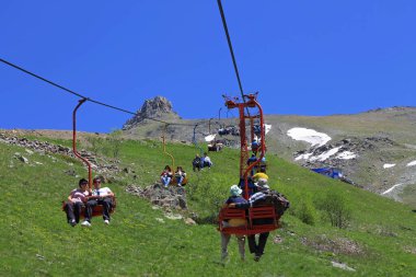 Kablo yolundaki çift sandalyeli insanlar. Dombai Dağları, Rusya Federasyonu 10 Haziran 2012