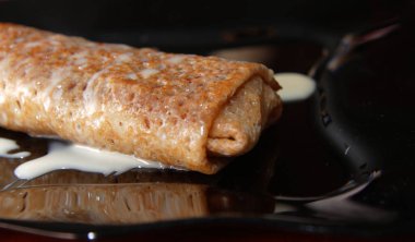 Siyah tabakta meyvelerle doldurulmuş leziz gözlemeler yakın plan ve yoğunlaştırılmış süt ocağı.