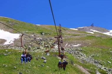 Kablo yolundaki çift sandalyeli insanlar. Dombai Dağları, Rusya Federasyonu 10 Haziran 2012