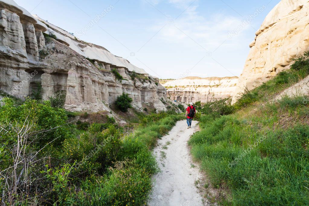 Travel to Turkey - tourist walks along pathway near Goreme town in Cappadocia in spring