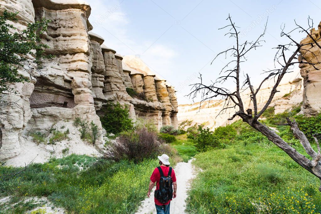 Travel to Turkey - tourist walks in ravine near Goreme town in Cappadocia in spring
