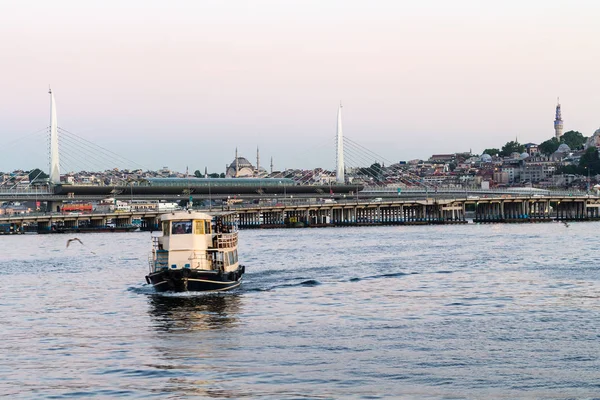 Travel to Turkey - excursion boat and view of Golden Horn Metro Bridge in Istanbul city in spring evening
