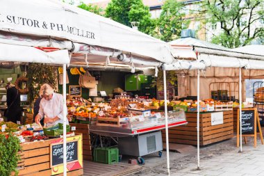 Münih, Almanya - 24 Mayıs 2018: satıcı Münih şehir meydanında Viktualienmarkt açık yerel gıda piyasada. Münih nın başkenti ve en kalabalık şehir Alman Bavyera devlet olduğunu