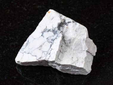 doğal kaya örnek - siyah granit zemin üzerine beyaz Howlite taş makro çekim