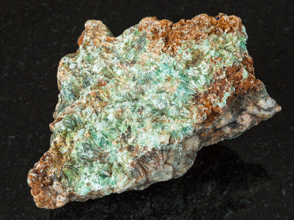 macro shooting of natural mineral - rough Pyrophyllite stone on black granite from Ural Mountains