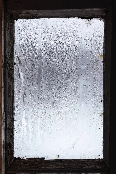 冬の古民家で曇った窓の表面に氷の融解から水します — ストック写真
