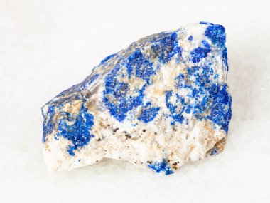 Doğal mineral - kaba Lazurite (Lapis Lazuli) taş Ural Dağları beyaz mermer üzerinde makro çekim