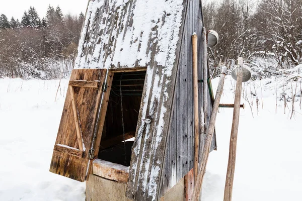 俄罗斯乡村森林边缘的露天井 用旧的典型工具 冰采摘和钢包 在俄国的摩棱斯克地区阴冬日 — 图库照片