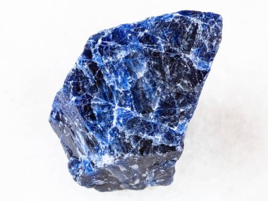 macro shooting of natural rock specimen - rough Sodalite gemstone on white marble background clipart