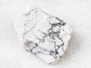 macro shooting of natural rock specimen - raw Howlite stone on white marble background clipart