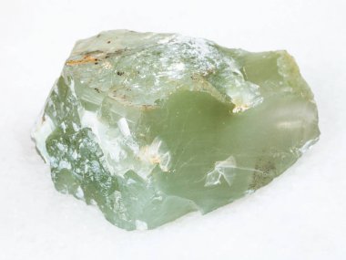 macro shooting of natural mineral - raw Prase (green quartz) stone on white marble from Ural Mountains clipart