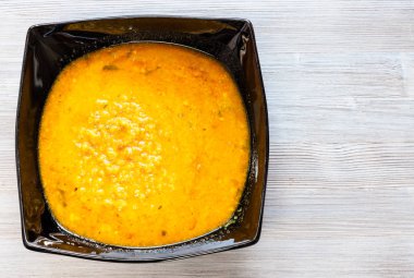 Hint mutfağı - sarı Dal Tadka mercimek köri ile gelen ev tarzı gri ahşap masa üzerinde siyah kase pişmiş