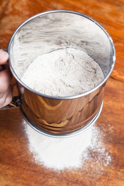 yemek pasta - elek ahşap masa üzerinde aracılığıyla un eleme