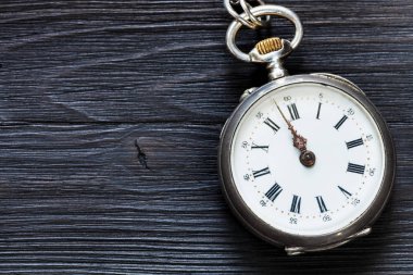 Saat oniki yönünde retro cep saati Siyah ahşap zemin üzerine tarih için iki dakika