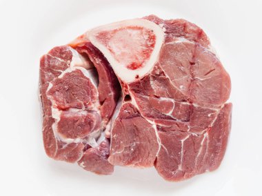 İtalyan yemek Ossobuco beyaz tabakta için iliği ile çiğ Dana eti dilim üstten görünüm