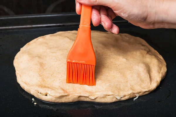 cooking of pie - oiling the raw pie by silicone brush