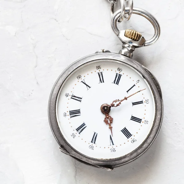 軽い灰色漆喰の背景に使用される銀懐中時計 — ストック写真