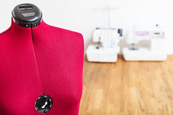 dressmaker dummy close up in tailor workshop with sewing machines