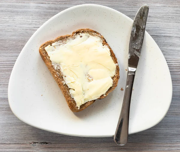 Brotsandwich Mit Butterbutter Und Stahlmesser Auf Weißem Teller Auf Grauem — Stockfoto