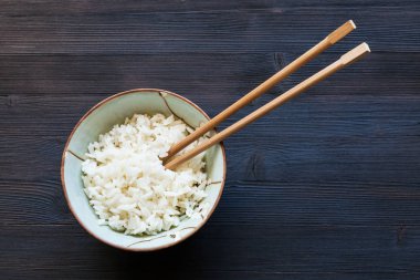kase haşlanmış pirinç yemek çubukları üstten görünüm koyu ahşap tahta üzerinde