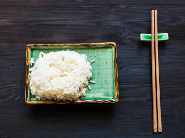 yeşil plaka ve dinlenme koyu kahverengi tablo üzerinde ahşap çubuk haşlanmış pirinç bölümünün üstten görünüm