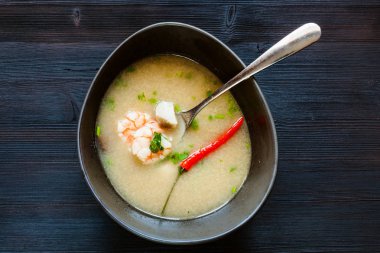 Tayland mutfağı yemek - Tom Kha Thale (Tom kha kai, Tom Kha Gai, Tay Hindistan cevizi çorbası) ile kase üstten görünüm ekşi ve baharatlı çorba karides ve koyu ahşap tahta üzerinde mantar ile