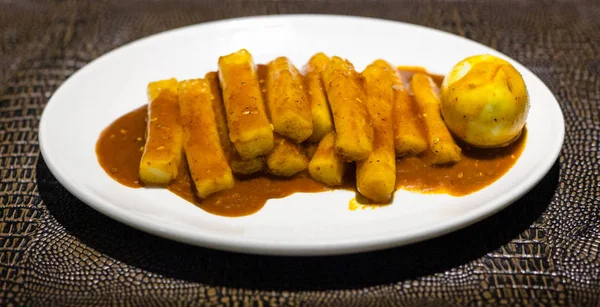 韩国菜 在当地餐馆的褐色叶子板上的白盘上的Tteok Bokki开胃菜 用辣酱煮鸡蛋的米棍 — 图库照片