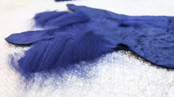 ワーク ショップ手作りフリース手袋からの青メリノ羊毛ウェット フェルト プロセスを使用 追加の線維とウェット フェルト手袋をクローズ アップ — ストック写真