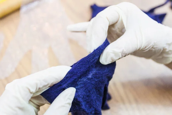 用湿法毛毡工艺用蓝色梅里诺羊毛羊毛羊毛手套制作的车间 工匠检查毛毡手套的边缘 — 图库照片