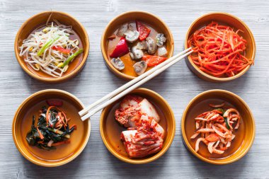 Kore mutfağı - Gri masa üzerinde çeşitli yan yemekleri (Banchan veya Panchan) olan yemek çubukları