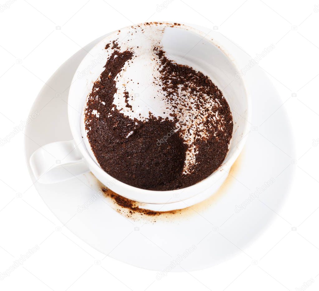 divination on coffee grounds - white porcelain cup with coffee sediments on saucer isolated on white background