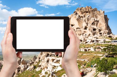 seyahat kavramı - Türkiye 'nin Kapadokya' da ilkbaharda kapadokya 'daki kaya kesimli Uchisar şatosunun turistik fotoğrafları akıllı telefondan ve boş bir ekran ile reklam için boş bir yer