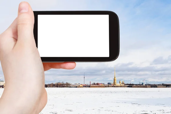 旅行概念 冻结的涅瓦河和彼得和保罗堡垒在圣彼得堡市的旅游照片在3月在智能手机与空的剪裁屏幕与空白的地方做广告 — 图库照片