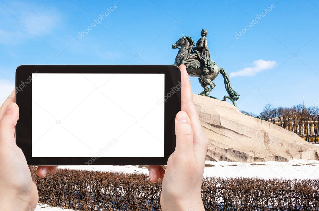 travel concept - tourist photographs of Bronze Horseman sculpture of Peter the Great in the Senate Square in Saint Petersburg city on smartphone with cutout screen with blank place for advertising