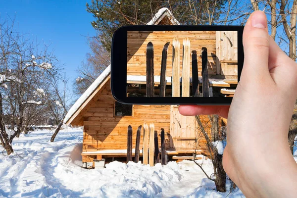 旅行概念 俄罗斯斯摩棱斯克地区在阳光明媚的冬日用智能手机拍摄的木制小屋前的广阔森林滑雪的旅游照片 — 图库照片