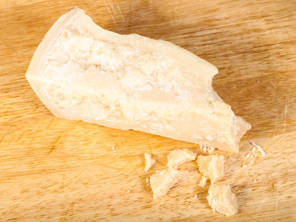 Tvrdý sýr parmezán s drobky na palubě — Stock fotografie