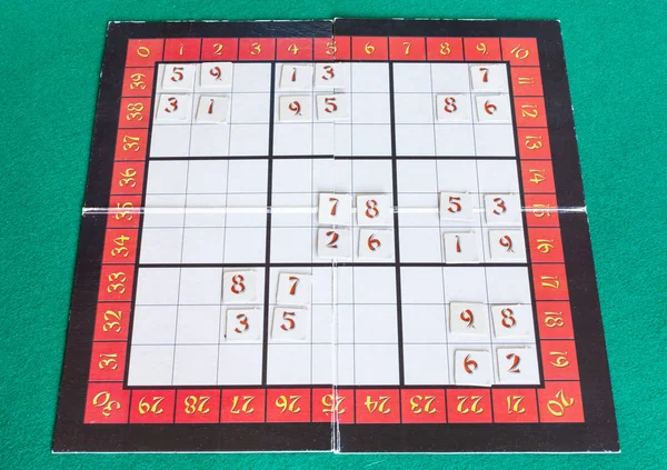 Sudoku board game on green baize table — Stock Photo, Image
