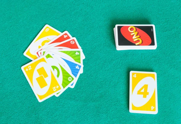 Card decks of UNO game on green baize table — Stock Photo, Image