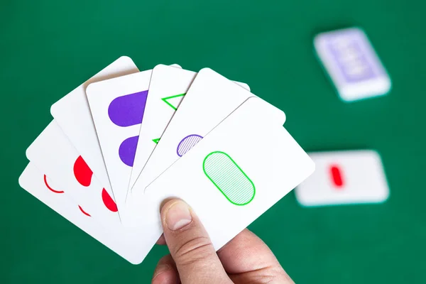 Player shows Set game cards over green table — Stock Photo, Image