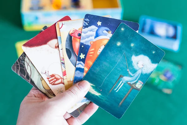 Spieler hält Bildkarten im Imaginarium Spiel — Stockfoto