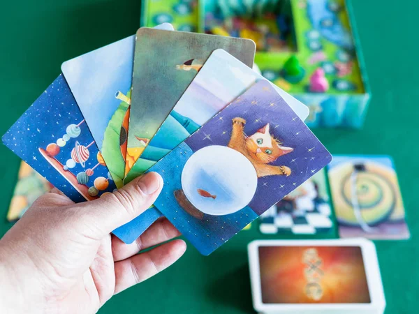 Spieler hält Bildkarten im Dixit-Brettspiel — Stockfoto